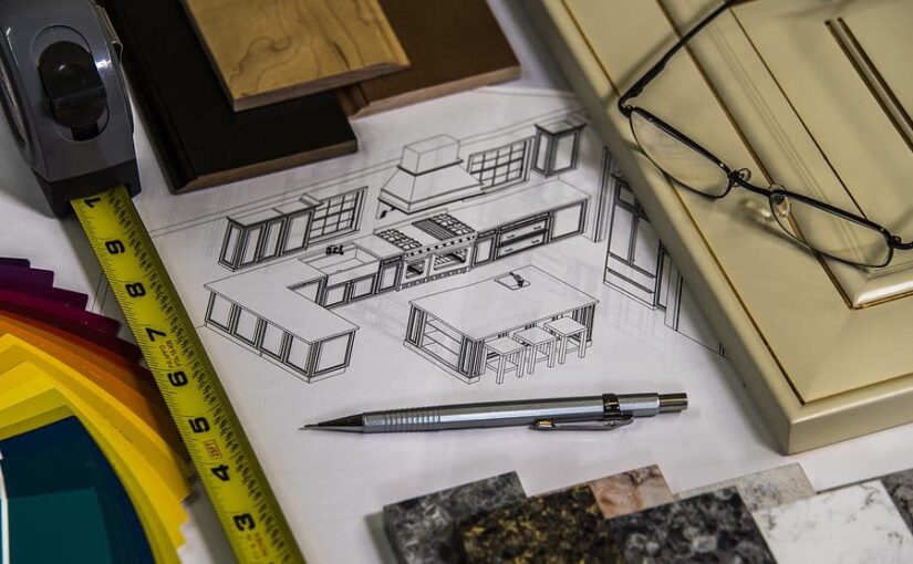 Designer's workspace with kitchen cabinet sketches, measuring tape, technical pen, material samples, and color swatches for interior remodeling project planning