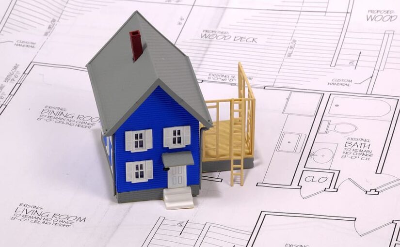 3D model of a blue house with gray roof and yellow deck sitting on architectural blueprints and floor plans